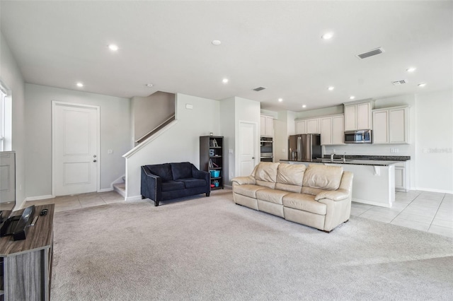 carpeted living room featuring sink