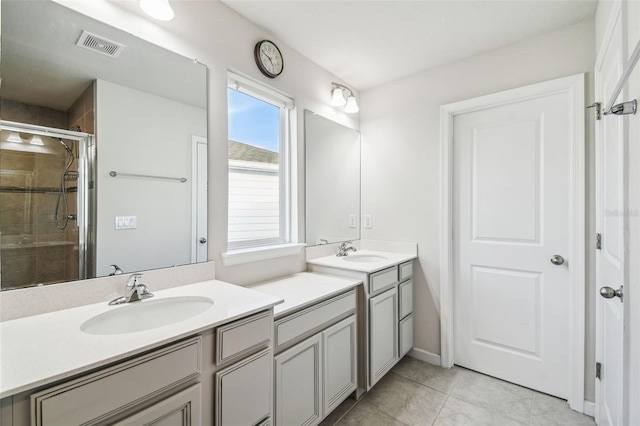 bathroom with vanity, a shower with shower door, and tile patterned floors