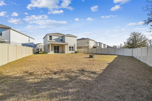 back of house featuring a yard and a fire pit