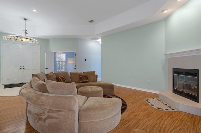 living room with a tile fireplace and light hardwood / wood-style floors