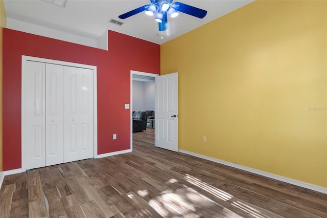 unfurnished bedroom with hardwood / wood-style floors, ceiling fan, and a closet