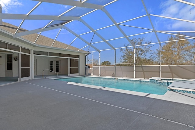 view of swimming pool with glass enclosure and a patio area