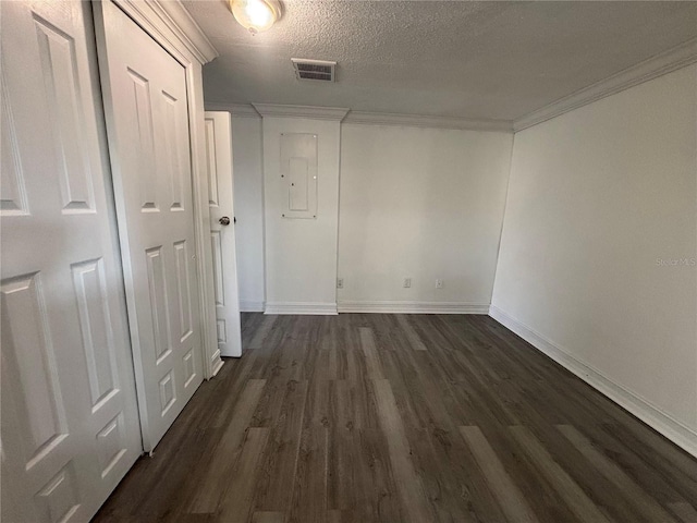 interior space featuring a textured ceiling, ornamental molding, dark hardwood / wood-style flooring, and electric panel