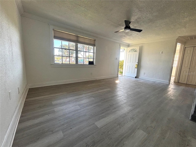 empty room with ceiling fan, dark wood-type flooring, a textured ceiling, and ornamental molding