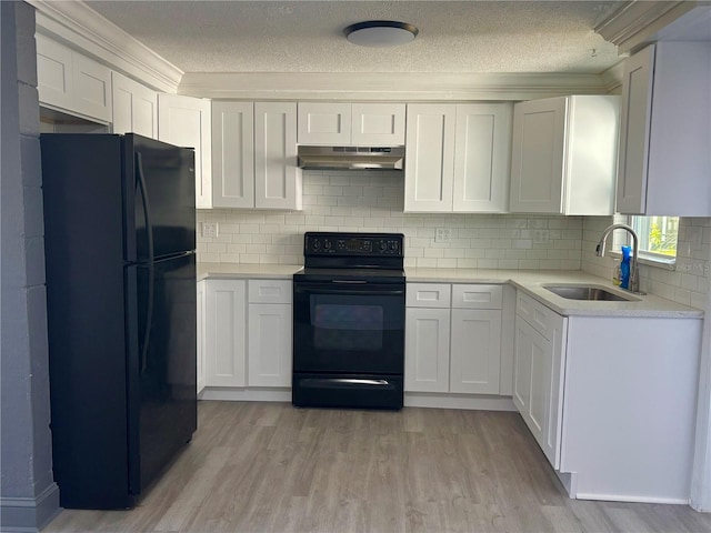 kitchen with black appliances, white cabinets, and sink