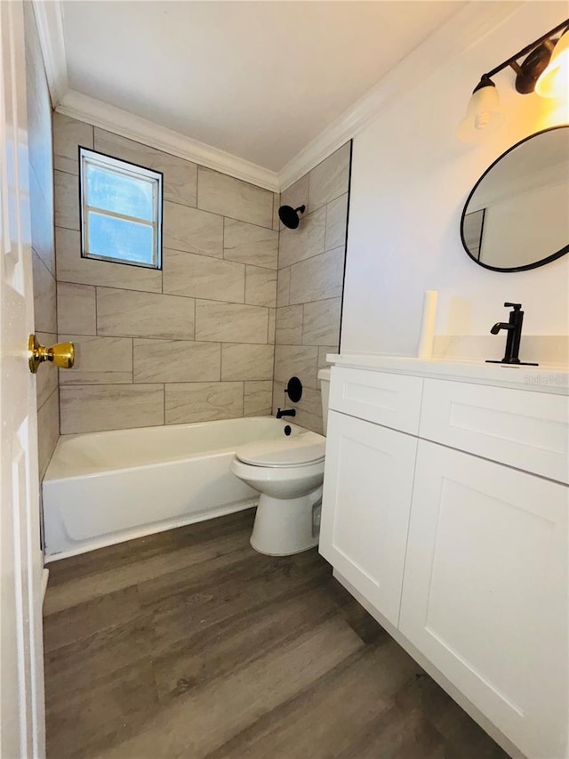 full bathroom featuring toilet, vanity, tiled shower / bath combo, hardwood / wood-style flooring, and ornamental molding