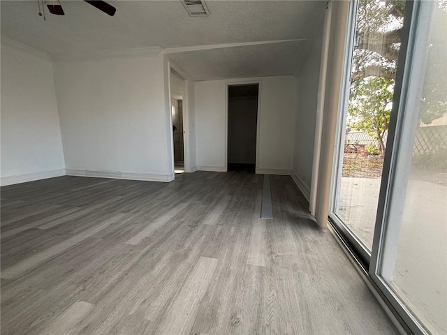 unfurnished room featuring ceiling fan, wood-type flooring, and a textured ceiling