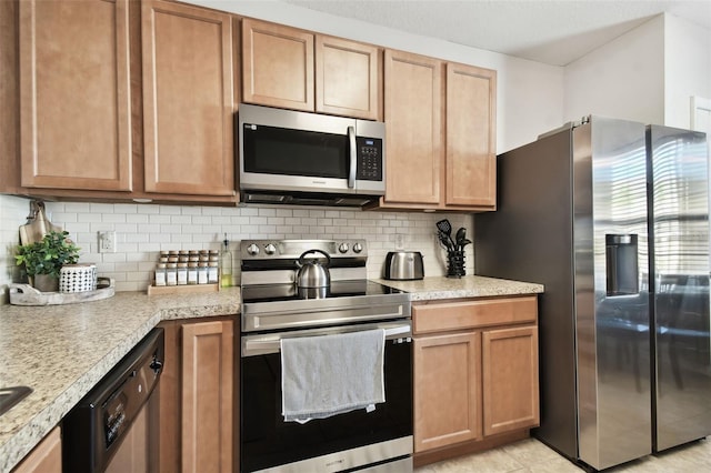 kitchen featuring light tile patterned floors, stainless steel appliances, and tasteful backsplash