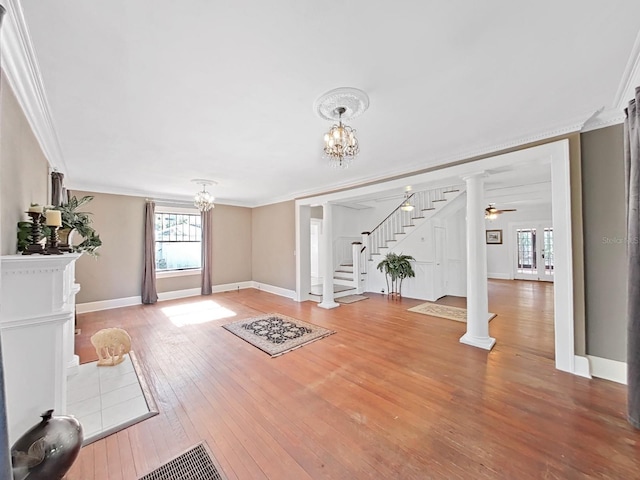 entrance foyer with ceiling fan with notable chandelier, hardwood / wood-style flooring, and crown molding