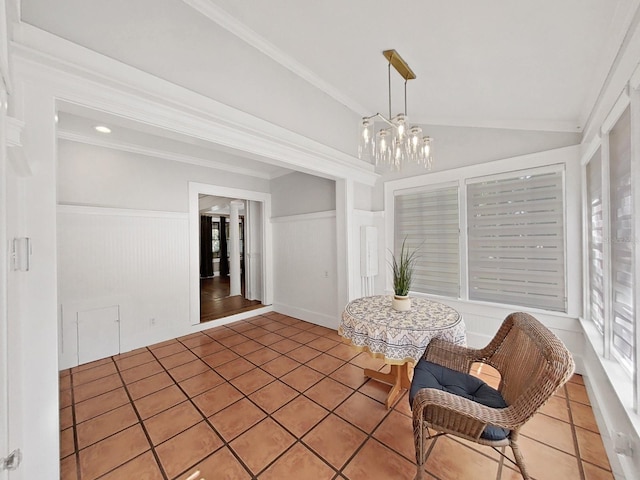 tiled dining area with lofted ceiling, an inviting chandelier, and ornamental molding