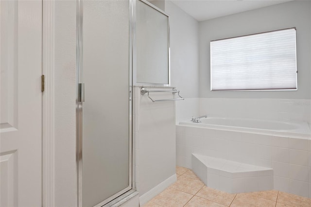 bathroom featuring tile patterned flooring and shower with separate bathtub