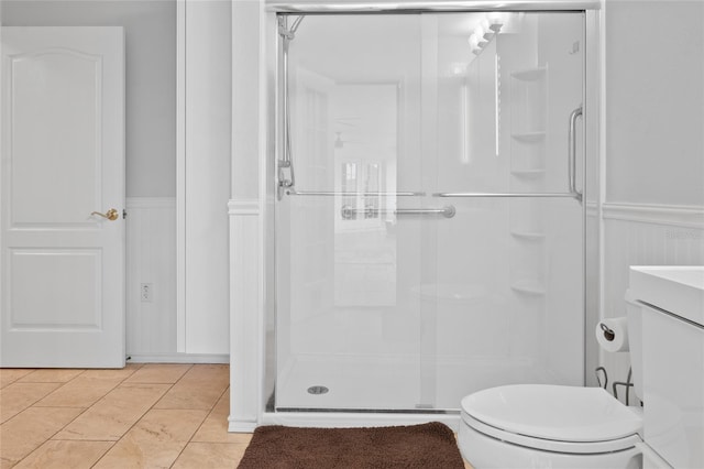 bathroom with tile patterned flooring, vanity, a shower with shower door, and toilet