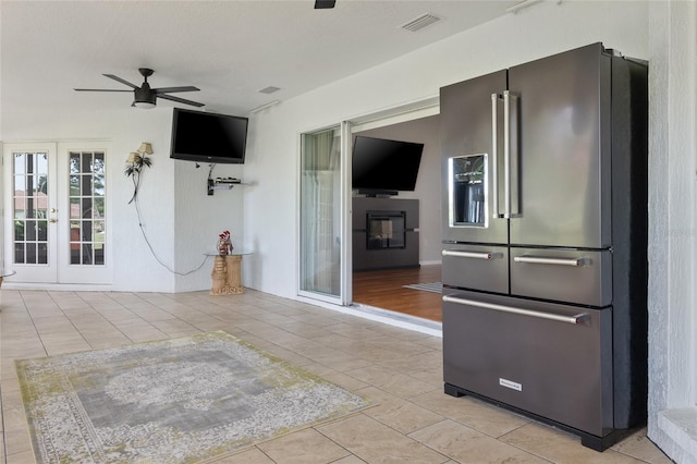 unfurnished living room with french doors, light tile patterned floors, and ceiling fan