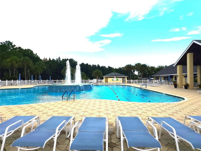 view of swimming pool with pool water feature and a patio