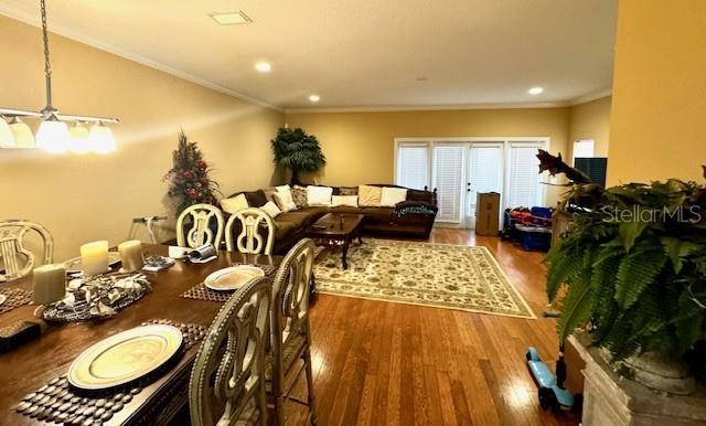 dining room with ornamental molding and hardwood / wood-style flooring