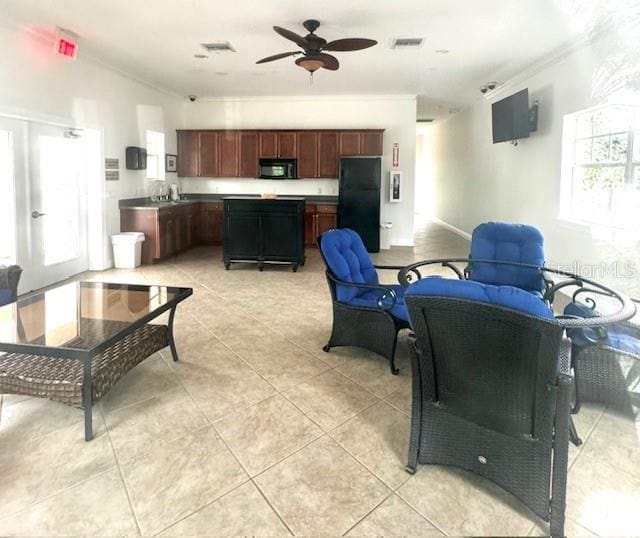 living room featuring ceiling fan, light tile patterned flooring, and ornamental molding