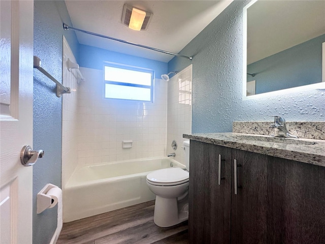 full bathroom with tiled shower / bath combo, wood-type flooring, vanity, and toilet