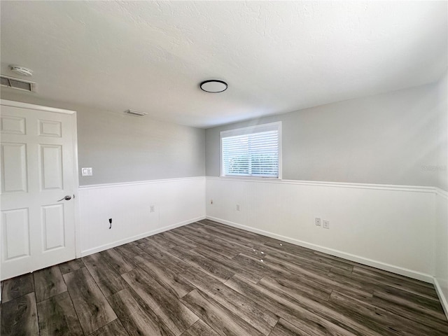 unfurnished room featuring dark wood-type flooring