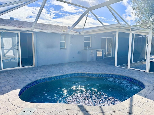 view of pool with a lanai, sink, and a patio