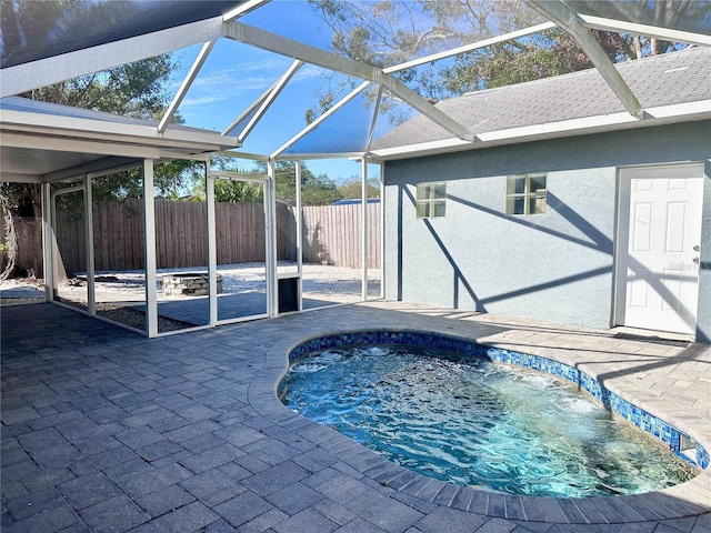 view of pool with a patio area and glass enclosure