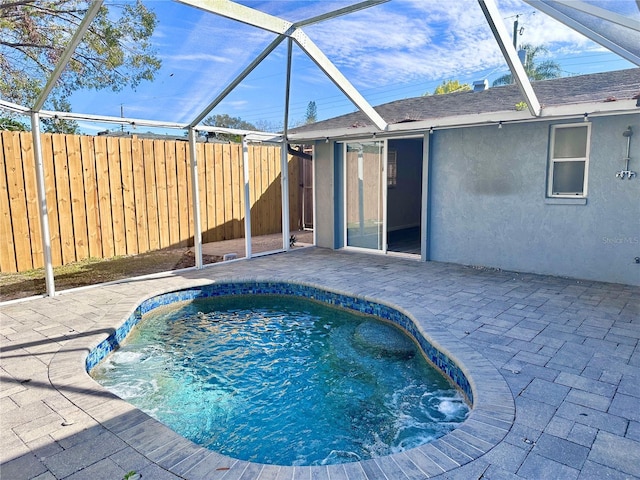 view of pool featuring glass enclosure and a patio