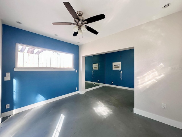 empty room with ceiling fan and a wall mounted air conditioner