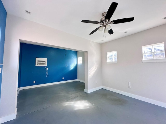 empty room featuring a wall mounted air conditioner and ceiling fan