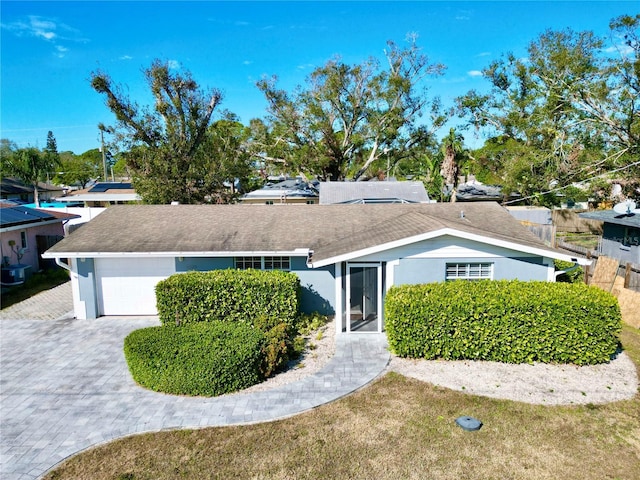 single story home with a garage and a front lawn