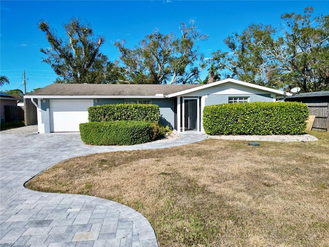 single story home featuring a garage and a front lawn