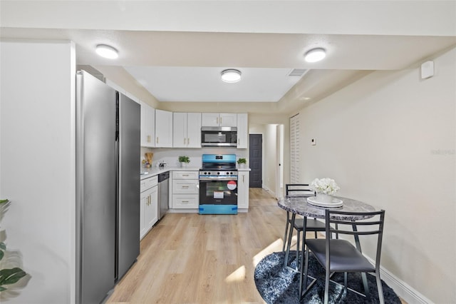 kitchen featuring white cabinets, light hardwood / wood-style floors, and appliances with stainless steel finishes