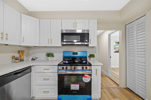 kitchen with backsplash, light hardwood / wood-style floors, white cabinetry, and stainless steel appliances