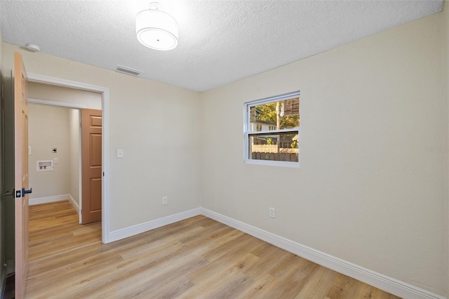 unfurnished room with light hardwood / wood-style floors and a textured ceiling