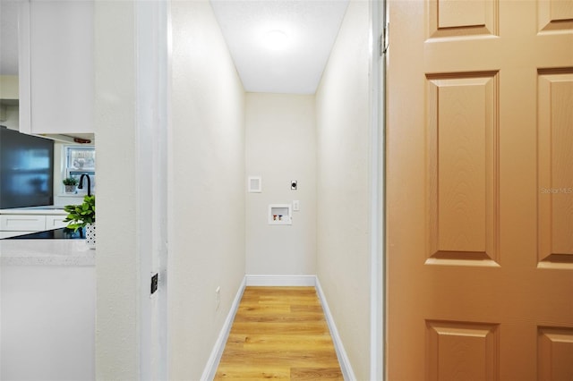 laundry area featuring light hardwood / wood-style flooring, electric dryer hookup, and sink