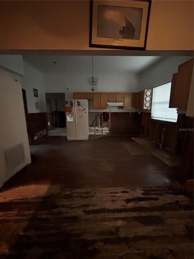 kitchen with white refrigerator and dark wood-type flooring