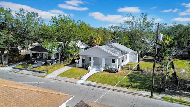 bungalow-style house with a front yard and covered porch