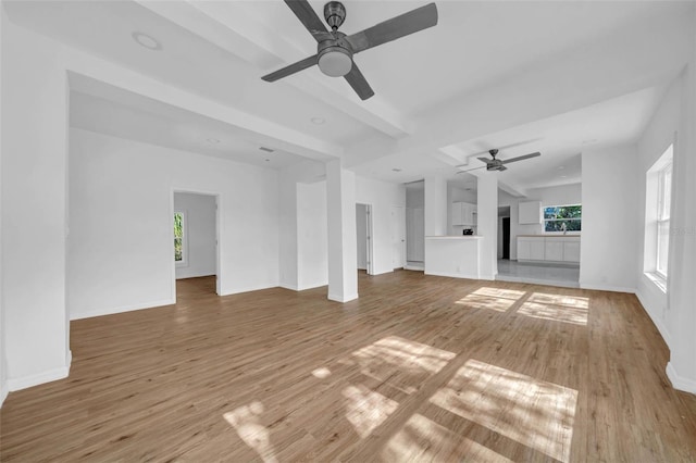 unfurnished living room featuring a wealth of natural light, hardwood / wood-style floors, and ceiling fan