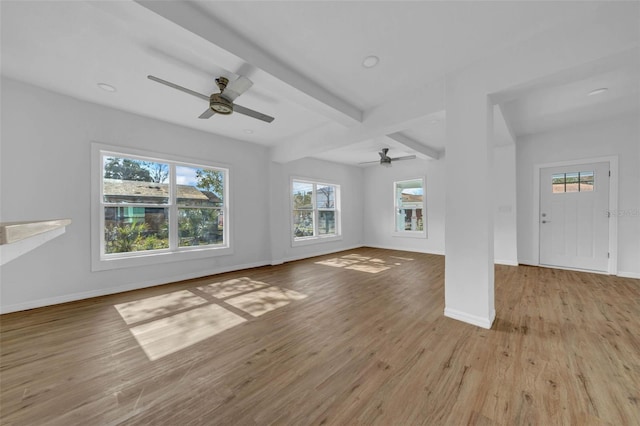 unfurnished living room featuring beamed ceiling, ceiling fan, and light hardwood / wood-style floors