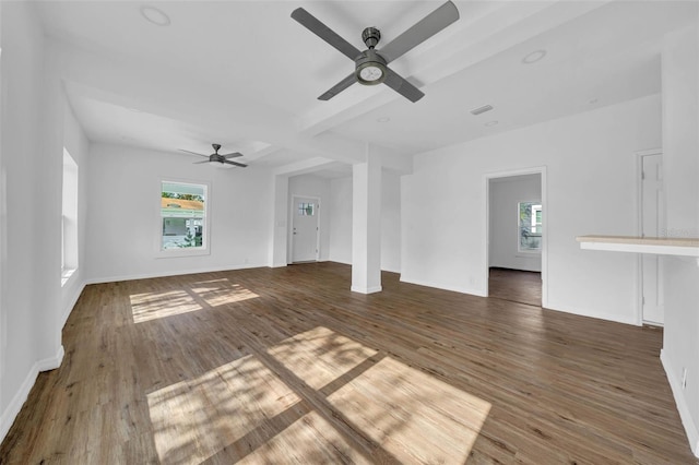 unfurnished living room with beam ceiling, dark hardwood / wood-style floors, ceiling fan, and a healthy amount of sunlight