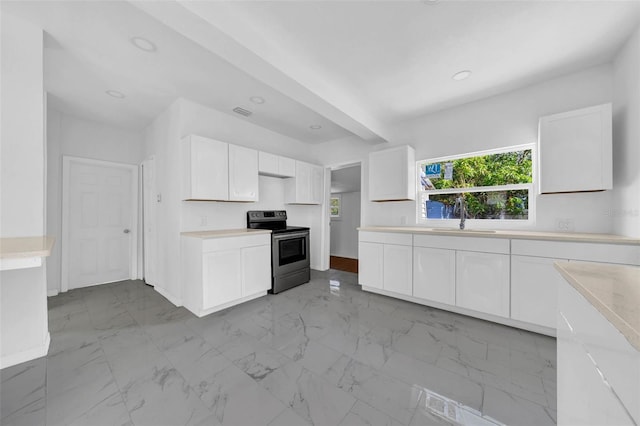 kitchen featuring stainless steel electric stove, white cabinets, and sink