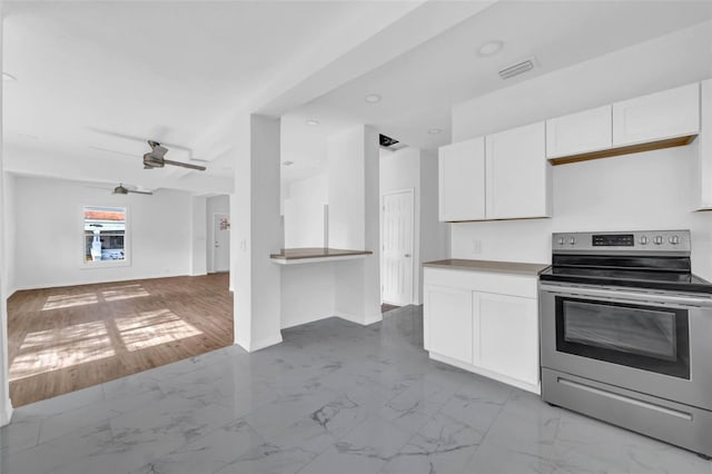 kitchen featuring white cabinets, electric range, and ceiling fan