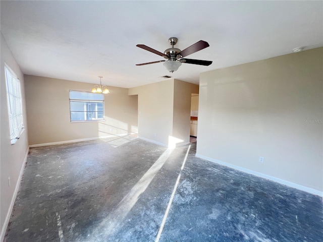 spare room featuring ceiling fan with notable chandelier