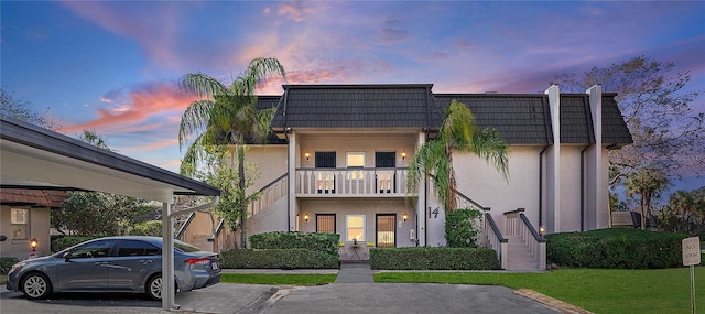 view of front facade with a yard and a balcony