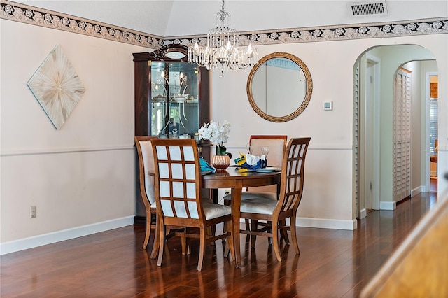 dining space with vaulted ceiling, dark wood-type flooring, and a chandelier