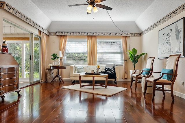 sitting room with a textured ceiling, dark hardwood / wood-style floors, vaulted ceiling, and ceiling fan