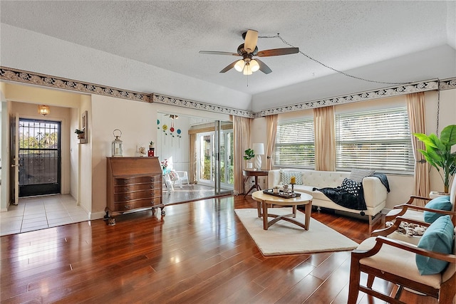 living room featuring ceiling fan, wood-type flooring, and a textured ceiling