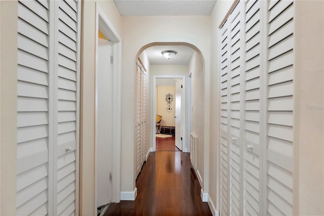 hallway featuring dark hardwood / wood-style floors and a textured ceiling