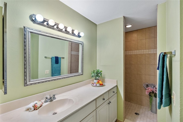 bathroom with vanity and tiled shower