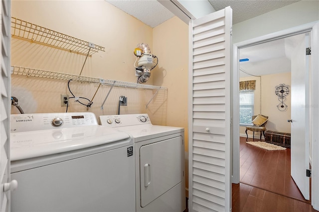 washroom featuring dark hardwood / wood-style flooring, washing machine and dryer, and a textured ceiling