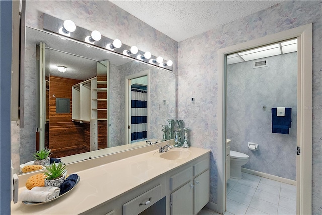 bathroom featuring tile patterned flooring, vanity, a textured ceiling, and toilet