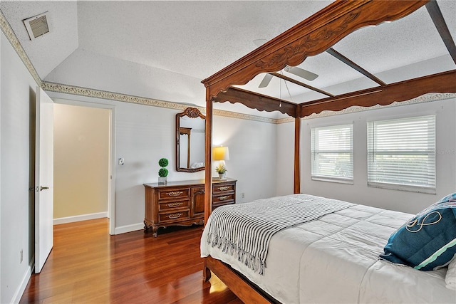 bedroom featuring hardwood / wood-style floors, a textured ceiling, ceiling fan, and lofted ceiling